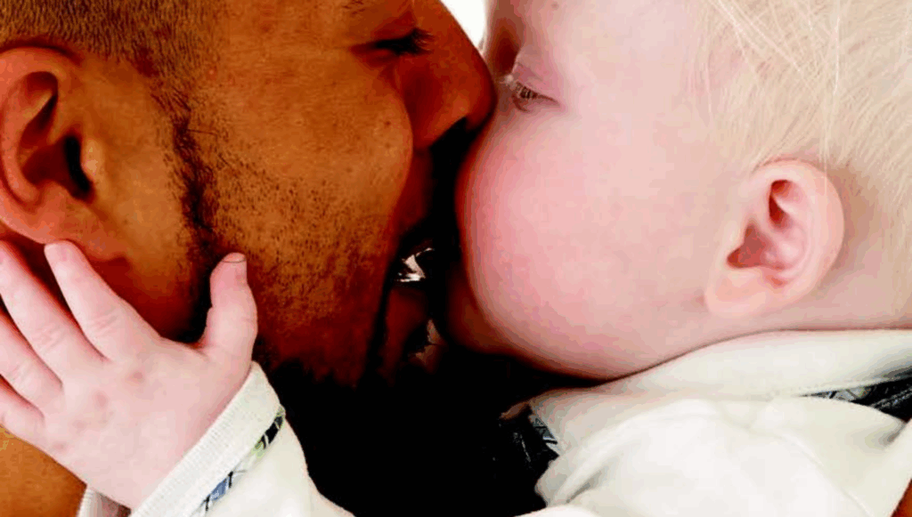 Baby boy kissing his father