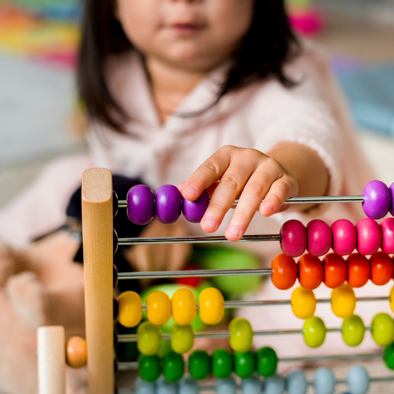 Little girl playing abacus for counting practice