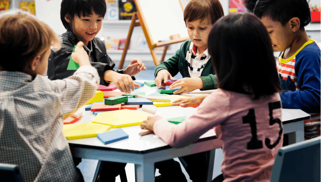Group of children sat around a table playing with colourful resources