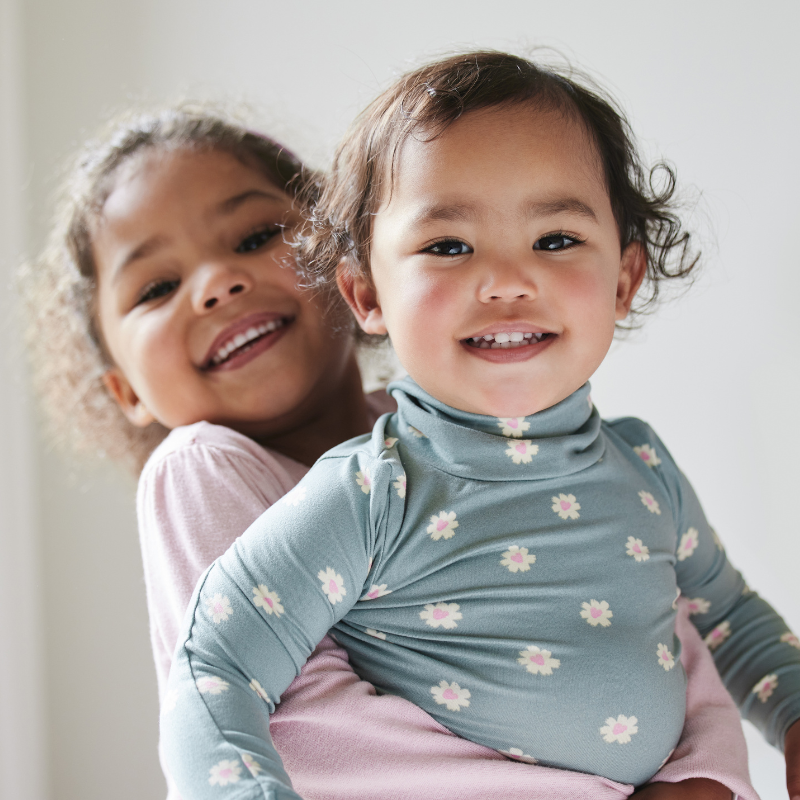 Girl lifting and hugging her younger sister