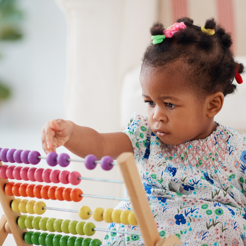 Little girls moving beads on a colourful abacus