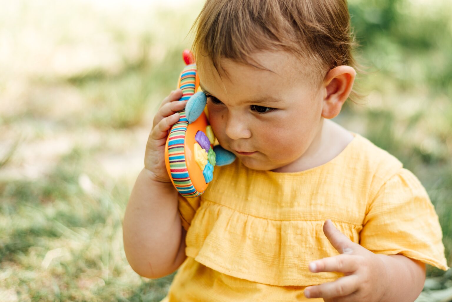 Little girl holding a toy phone to her ear