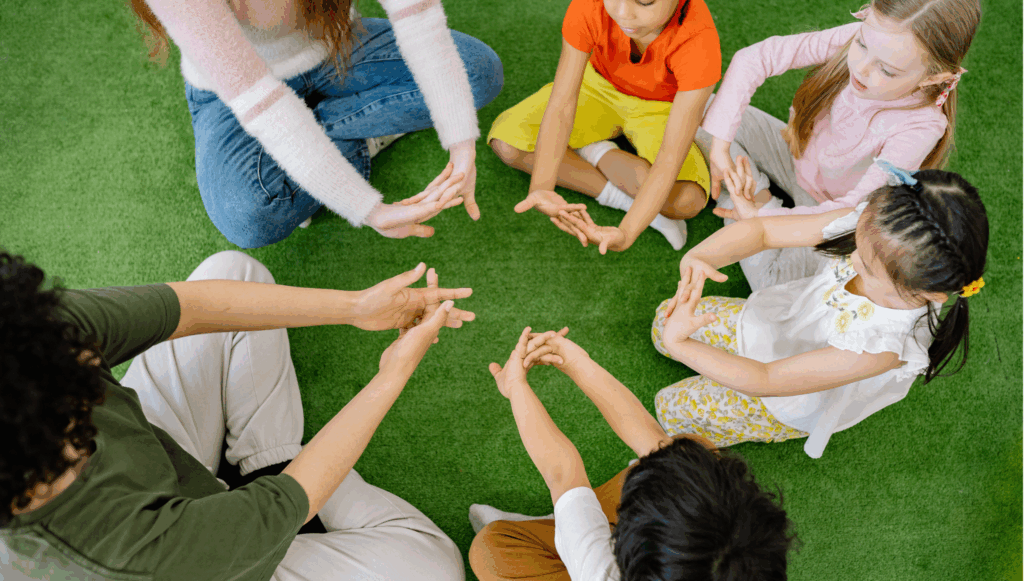 Group of child sat around on grass in a circle