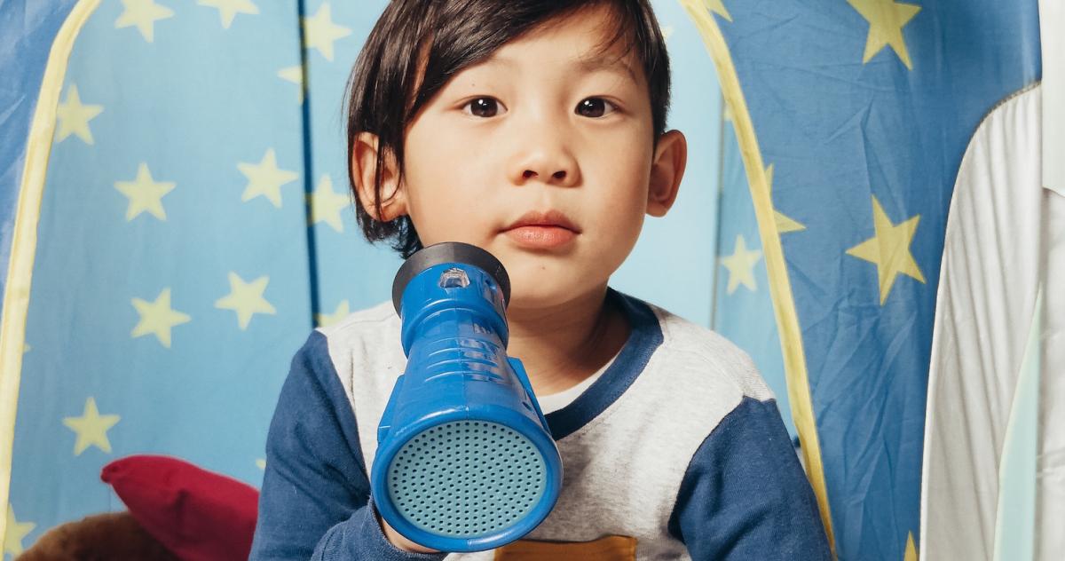 Little boy holding a toy megaphone looking at the camera