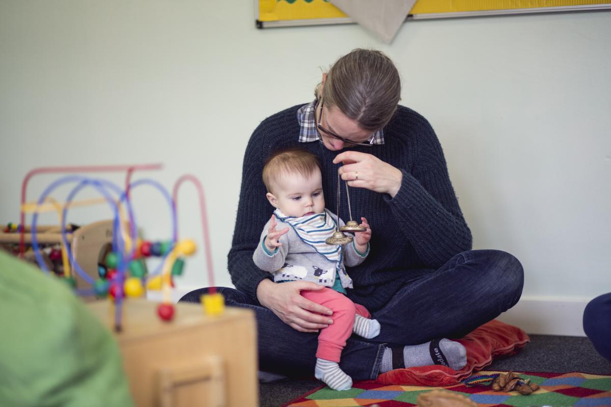 A woman plays with baby at nursery