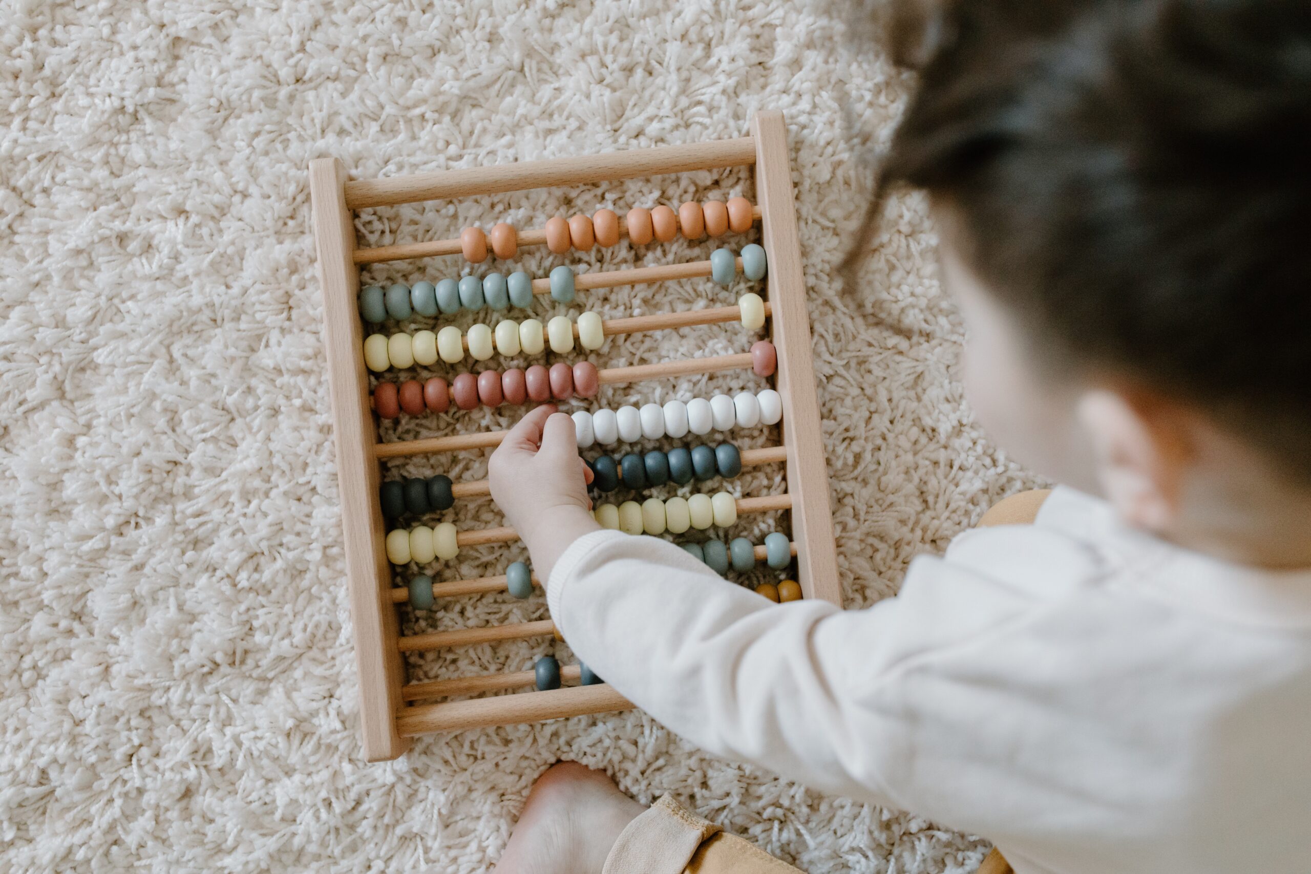 child playing with wooden abacus