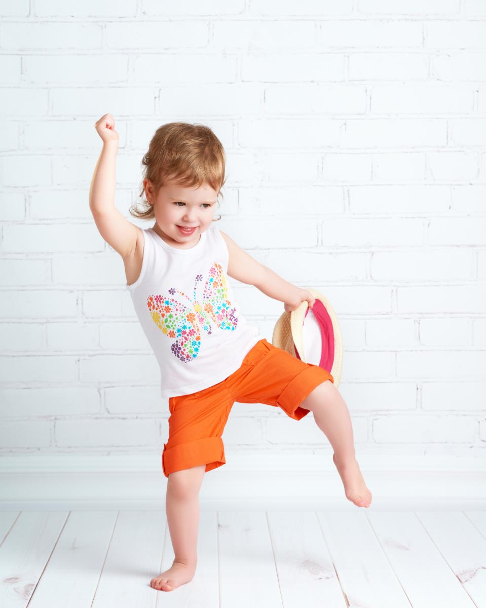 young girl dances with tambourine