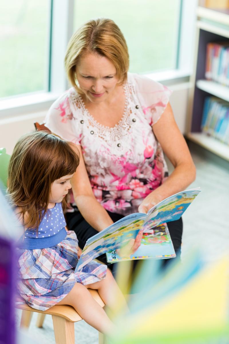 A woman reads with a young girl