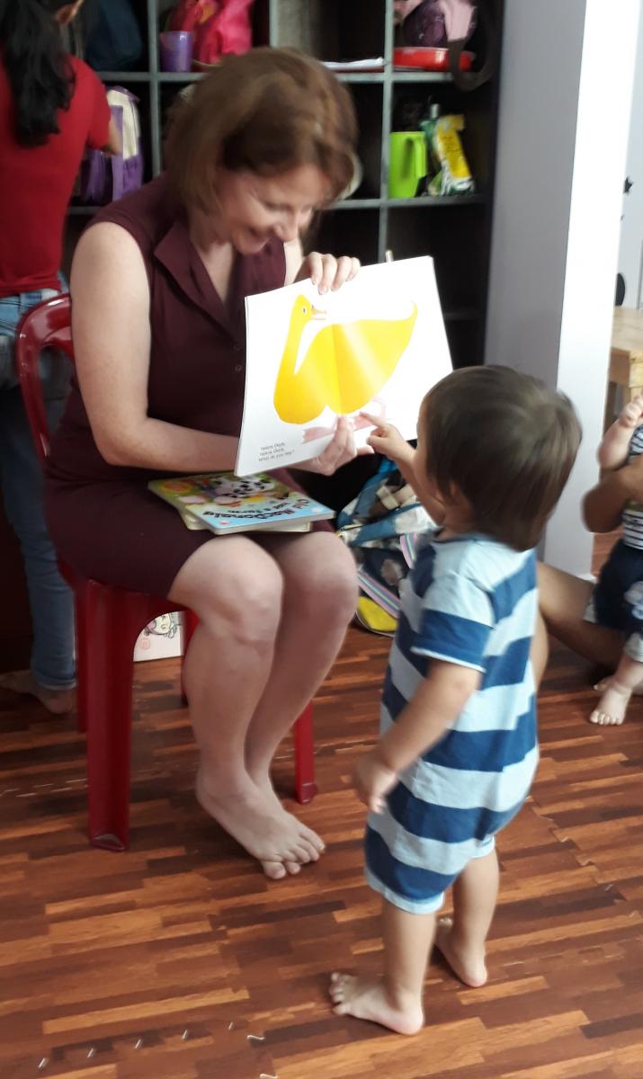 a young woman and boy explore a picture book together