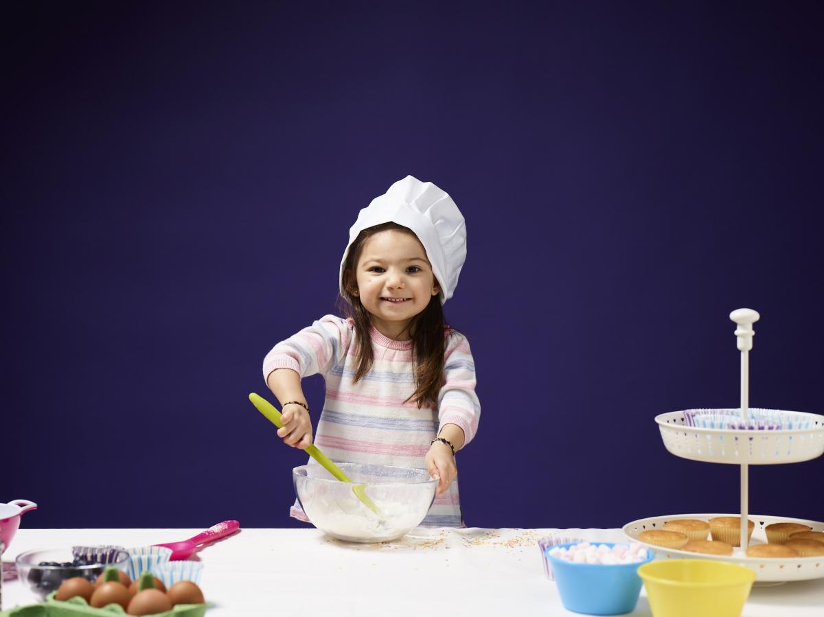 a young girl enjoys baking, mixing ingredients