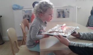 Young girl blowing out candles on her birthday cake