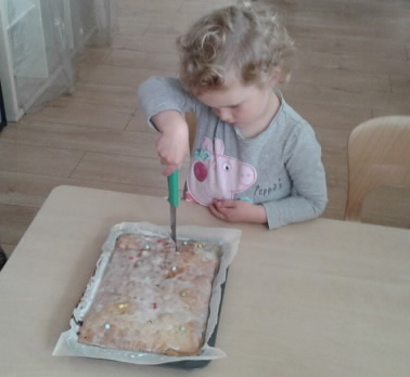 A young girl cuts her birthday cake