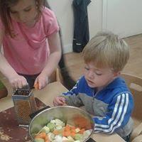 Children grating and preparing vegetables for soup