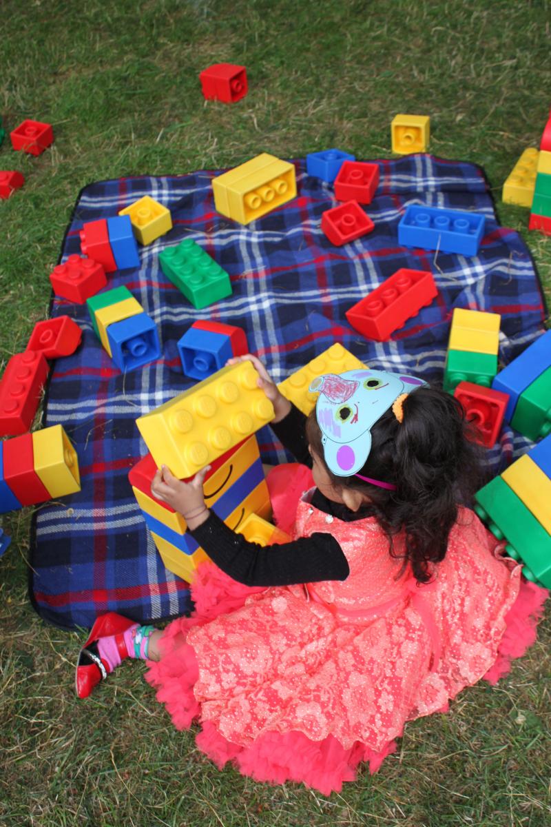 young girl plays with oversize lego