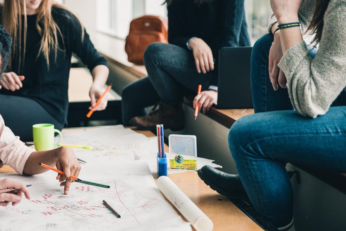 a group of people share ideas around large notepad