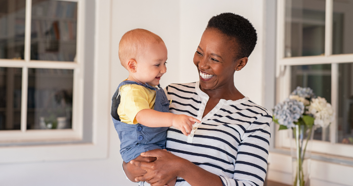 Smiling woman holding a happy baby