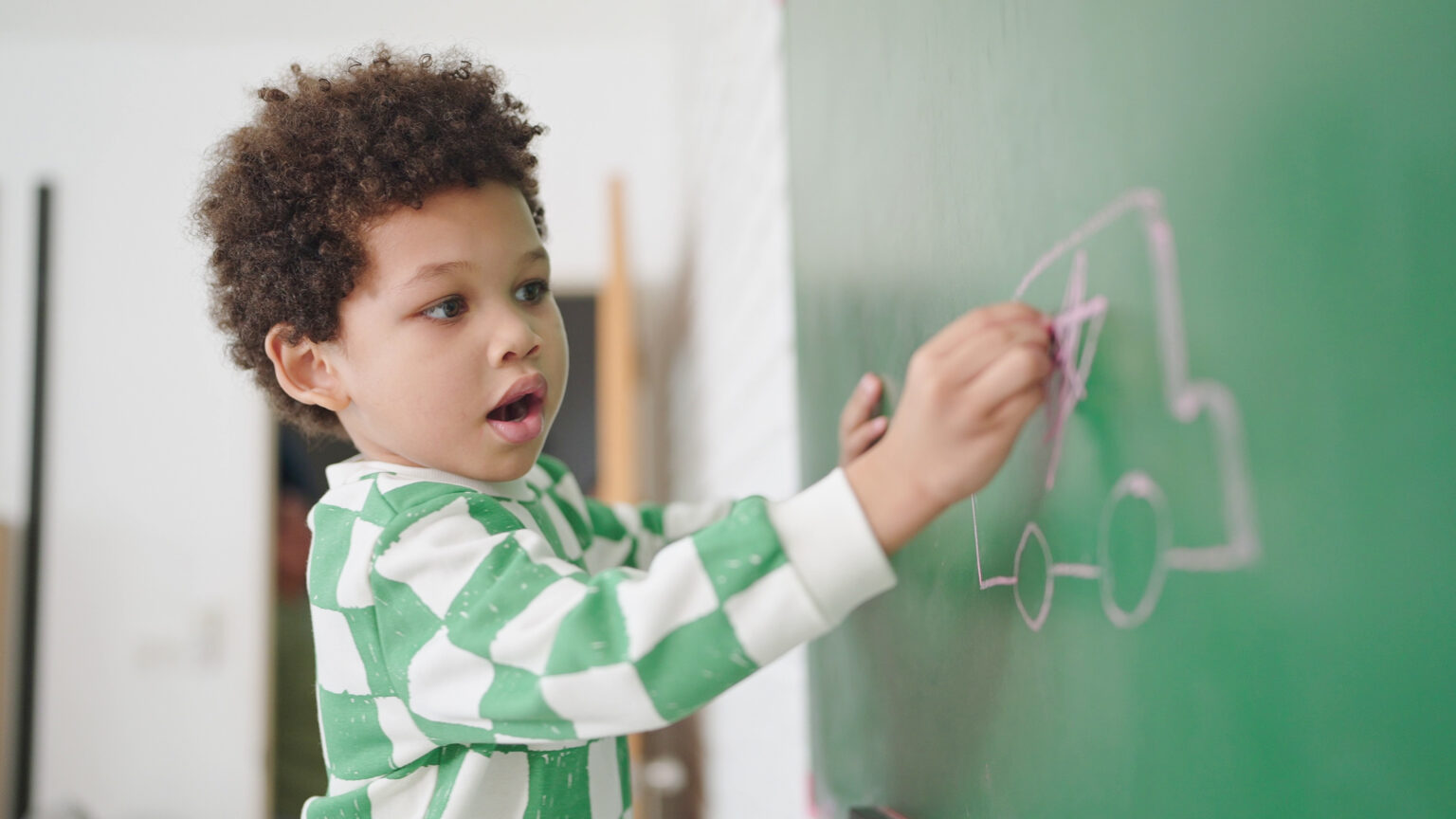 Little boy writing on a chalkboard
