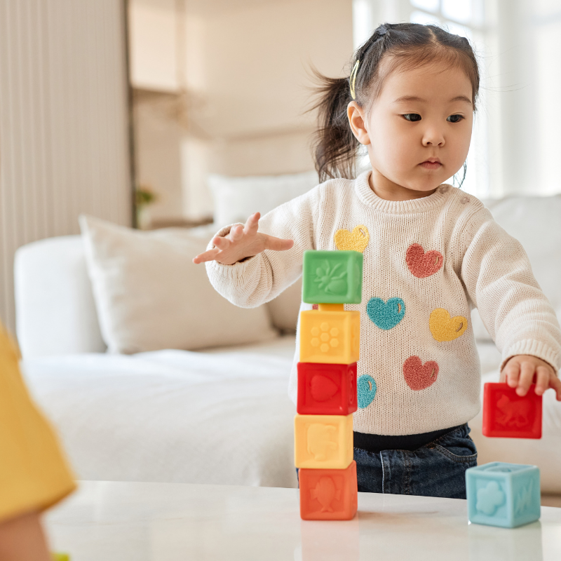 Children playing with colourful blocks in a living room