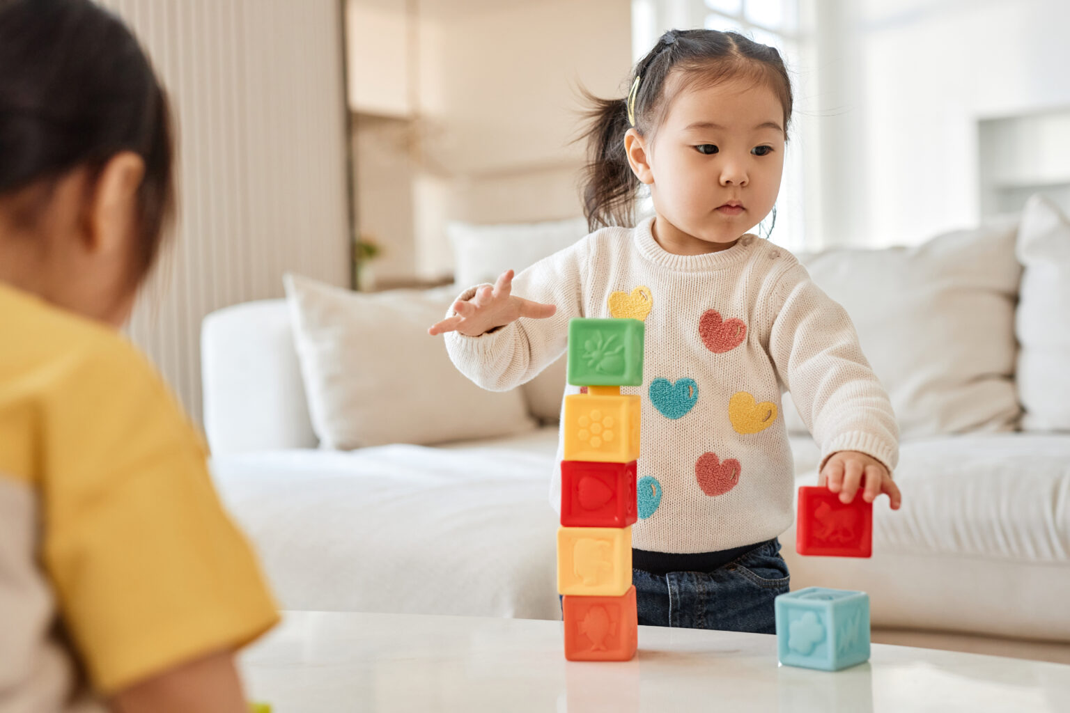 Children playing with colourful blocks in a living room