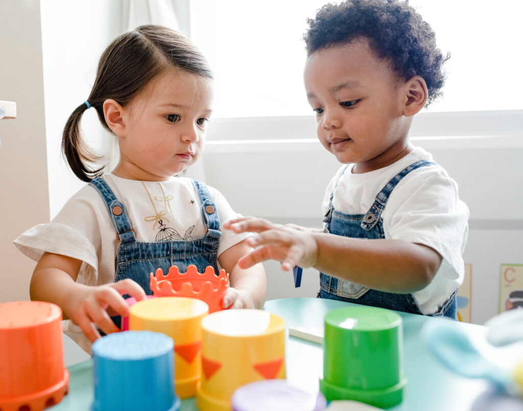 Little boy and girl playing with colourful toys